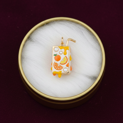 Orange juice box charm in gold tin box